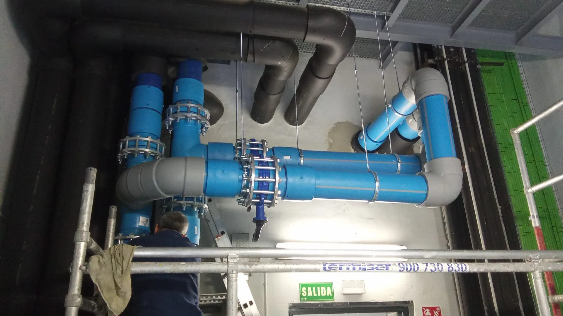 Colector de tuberías azules de gran diámetro con válvulas en una sala técnica
